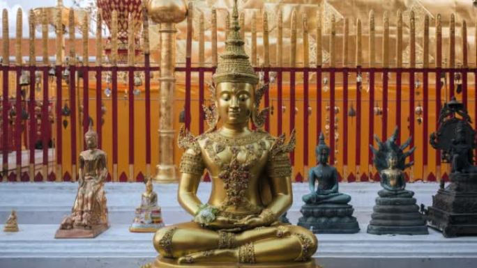 在泰国清迈的土素贴寺，佛教信徒在主塔周围散步，前景是一尊安详的佛像