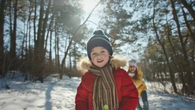带雪橇的积极家庭在冬季森林里玩得开心
