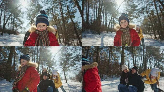 带雪橇的积极家庭在冬季森林里玩得开心