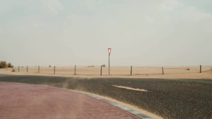 覆盖着沙漠沙子的柏油路。