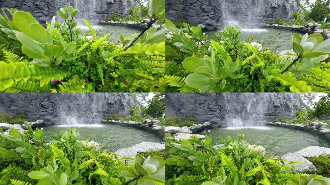 带喷泉和金鱼的装饰池塘，带瀑布喷泉的鱼塘