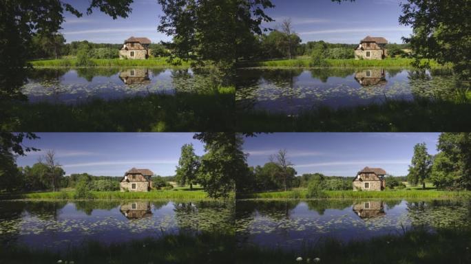 夏天池塘边的乡村石屋