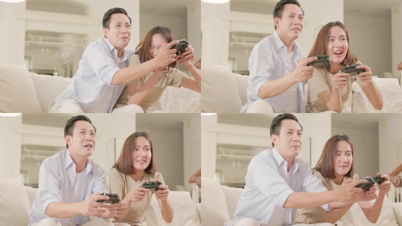 恋爱中的情侣坐在沙发上，使用控制器玩电子游戏。恋爱中的竞争女友和男友在家一起玩在线视频游戏