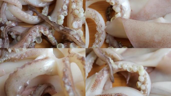 带有吸盘的触须和砧板上的生鱿鱼。新鲜海鲜和烹饪。