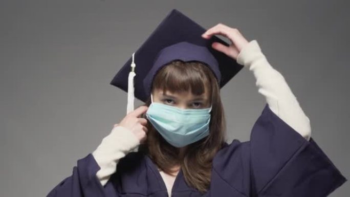戴鸭舌帽，脱下防护面罩的毕业女生。女学生微笑着向空中扔帽子。