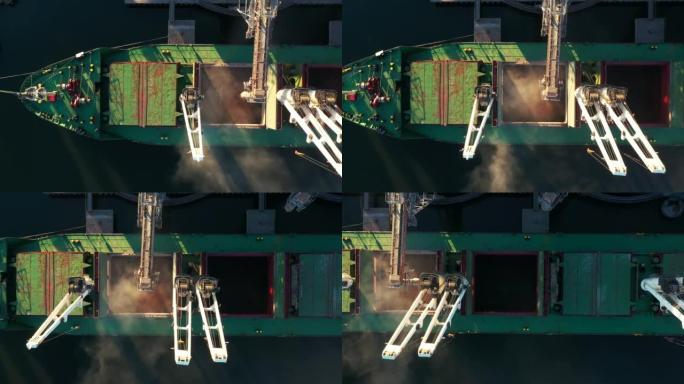 在海港的海粮升降机上，将小麦装载到散装船货舱的鸟瞰图。通过海港码头的移动干线将小麦从筒仓运到船上。海