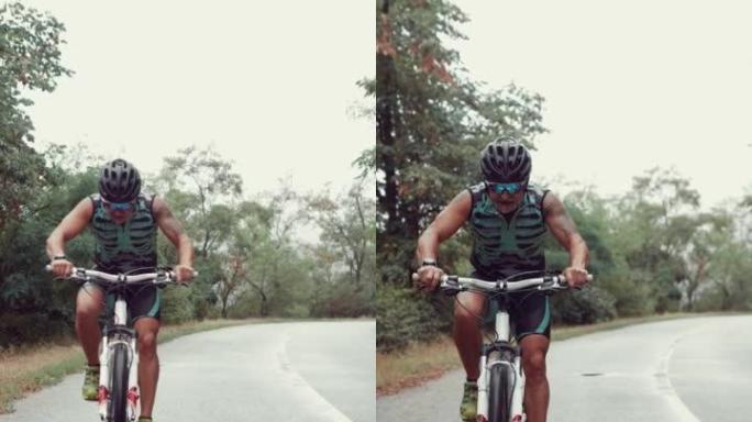 男子运动员骑自行车上路的垂直慢动作镜头