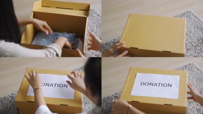 亚洲妇女将衣服放在盒子里捐赠