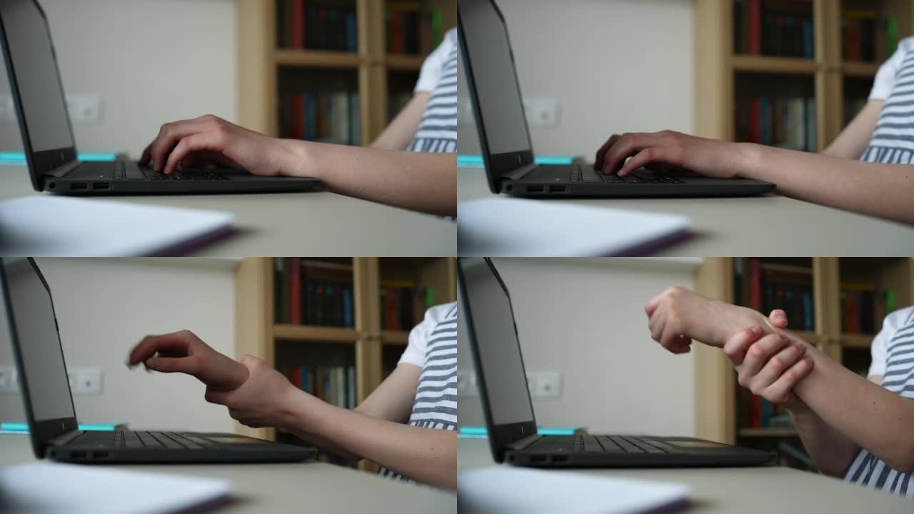 无法辨认的小学生女孩在笔记本电脑上打字时手腕疼痛的特写侧视图，坐在桌子旁做作业。
