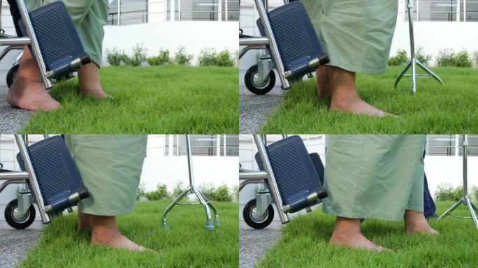 老年残疾人士从轮椅上站起来，高龄患者试图从轮椅上站起来的脚。脚踩在绿色草地后，成功的康复理念。
