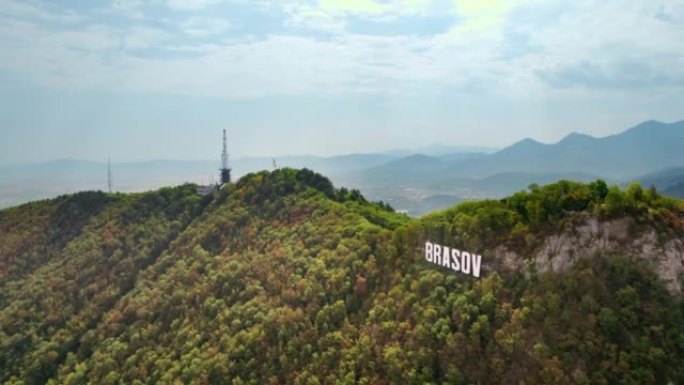 布拉索夫标志着游客在城市附近的山顶上，周围是绿树，罗马尼亚。古老的城市中心，拥有古老的建筑