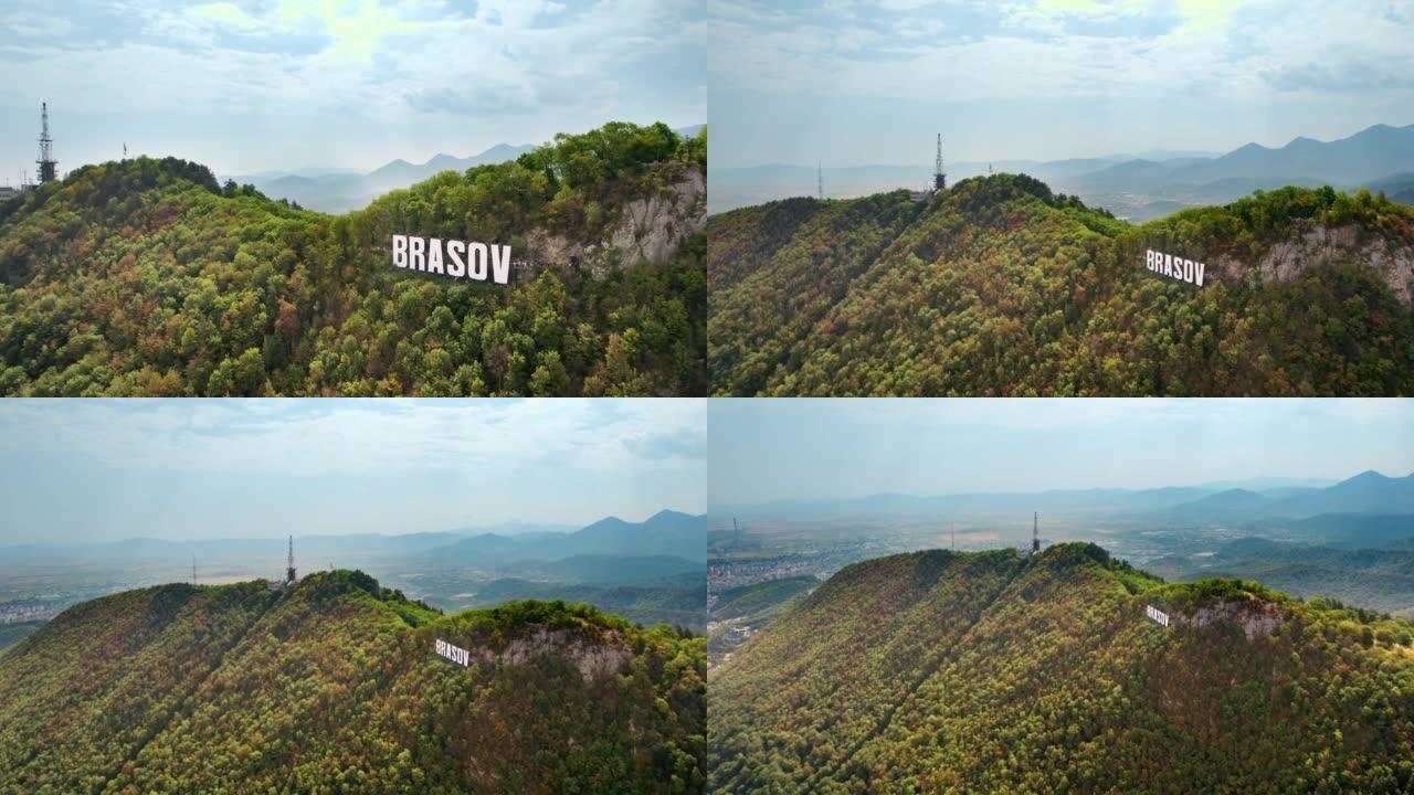 布拉索夫标志着游客在城市附近的山顶上，周围是绿树，罗马尼亚。古老的城市中心，拥有古老的建筑