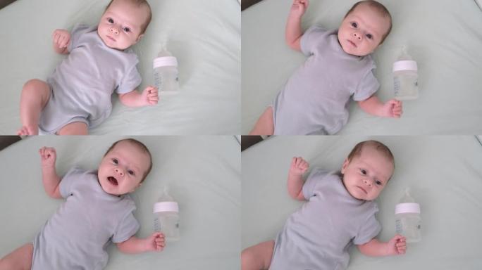 婴儿奶瓶在家里的婴儿婴儿床，肖像婴儿饱食的婴儿刚刚喝了奶粉。