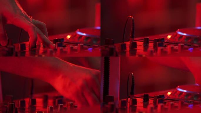DJ手和手指在他控制调音台板机之间闭合。