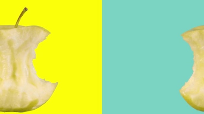 咬掉成熟的黄色苹果，核心，在彩色的黄蓝色背景上旋转。简约动画设计风格。元素概念空白背景模板。最小运动