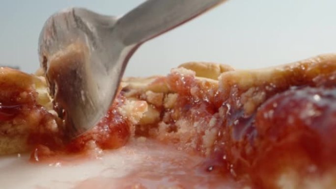 用樱桃果酱馅饼，我用叉子打碎一块，拿走。特写。