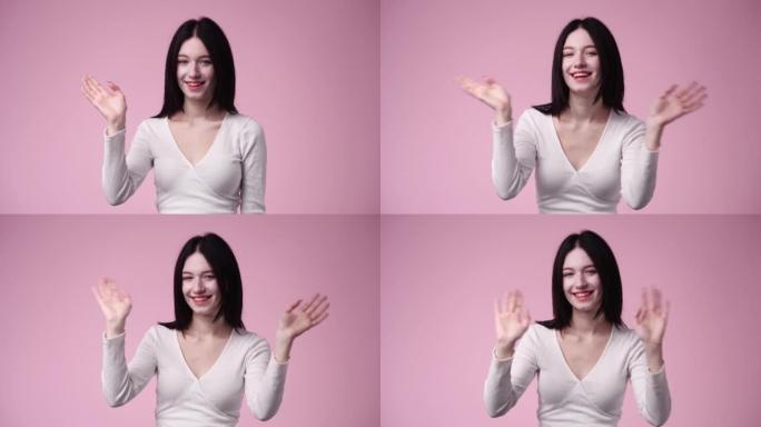 4k视频，女人在粉红色背景上挥手。
