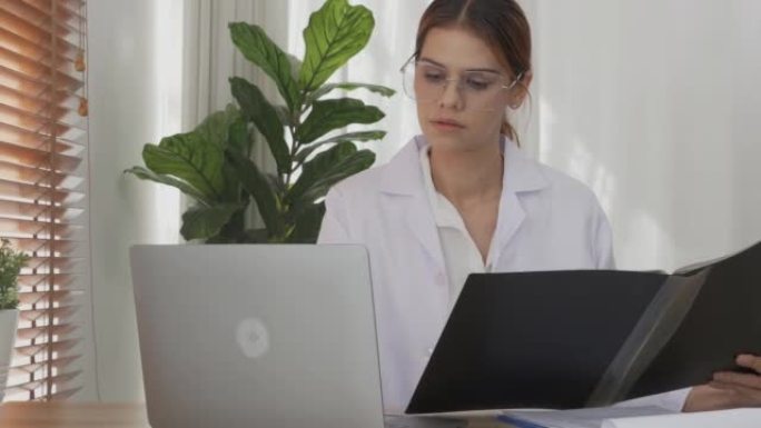 年轻的女医生在诊所的剪贴板上看病人疾病的文件文件夹，女性在医院检查的报告文件，一个人，医疗概念。