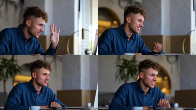 快乐的年轻白人男子微笑着挥手看着笔记本电脑屏幕，并在餐厅在线聊天。有视频会议的帅哥。休闲。慢动作