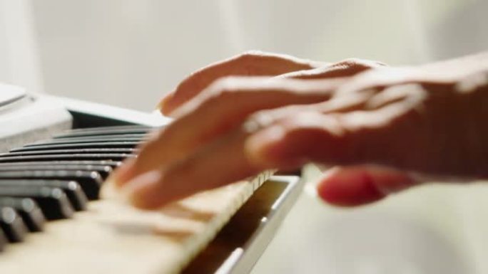 成人在家通过窗口附近的移动应用学习演奏键盘乐器，生活方式概念。身体部位。