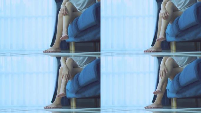 Beautiful asian woman scratching her leg while sit