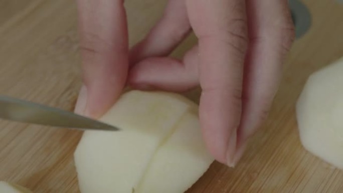 女人把去皮的苹果切成小块。
