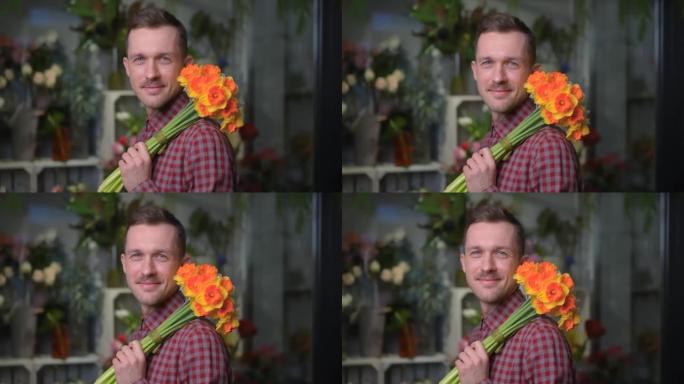 Cheerful male holding yellow and orange flower bou