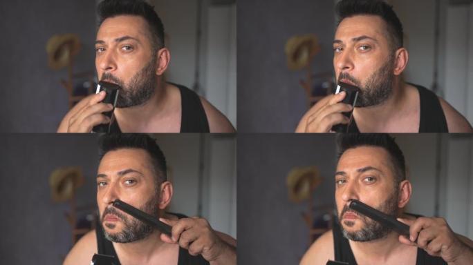 专注的男性在梳理完胡子后修剪胡子