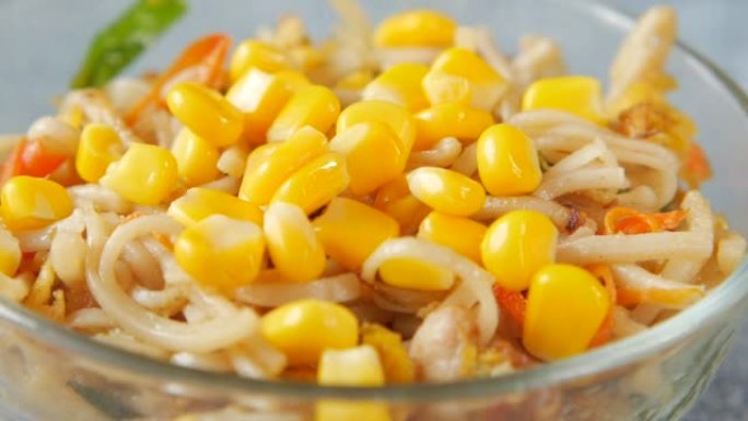 将玉米放入一碗面条中的慢动作