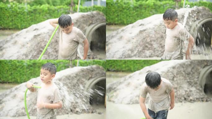 孩子们在社区田野里玩泥巴滑梯后洗泥。父母从远处看着