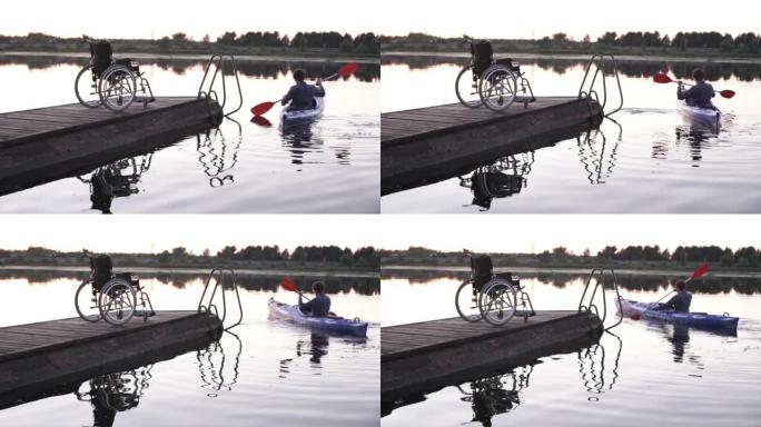 一名残疾男子在金色日落的背景下划独木舟。统一与自然的和谐