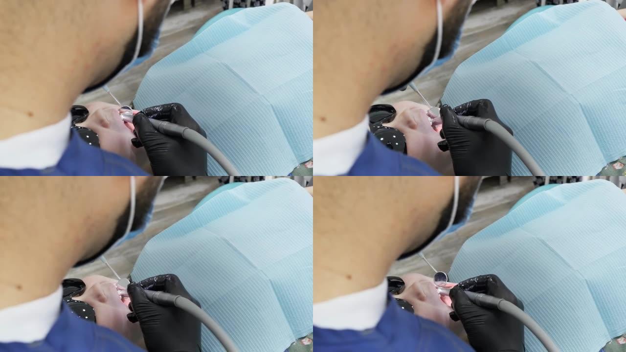 顶视图牙医用钻头和带手柄的口镜在一个小女孩身上钻一颗牙。学龄前儿童龋齿填充的过程。卧姿牙齿的治疗