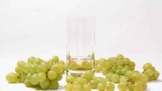 一杯葡萄汁和一束绿色葡萄