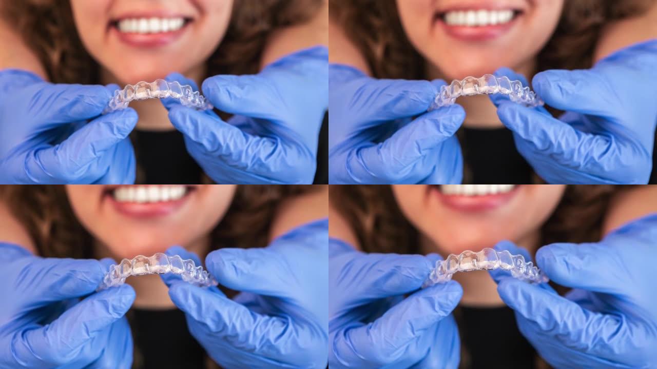 正畸医生将硅胶隐形透明牙套放在女性牙齿上