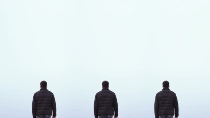 Three men walk with their backs