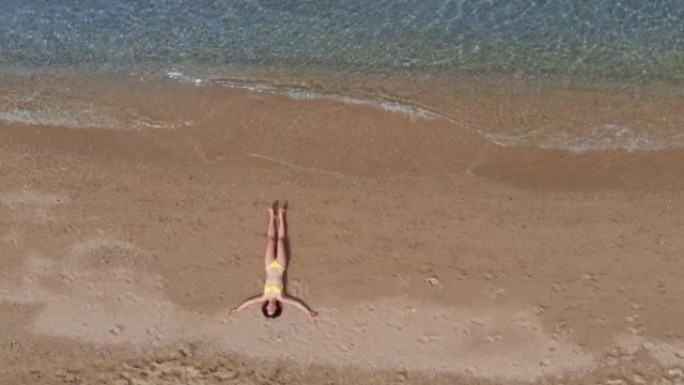 在海滩上放松的女人的无人机视图