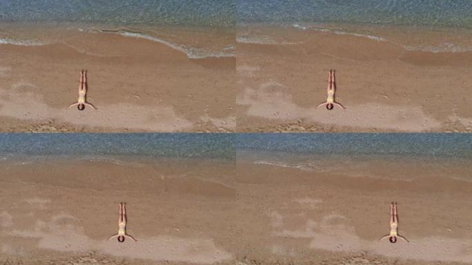 在海滩上放松的女人的无人机视图