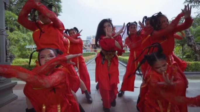 一群穿着红色服装的中国孩子在中国门口跳舞