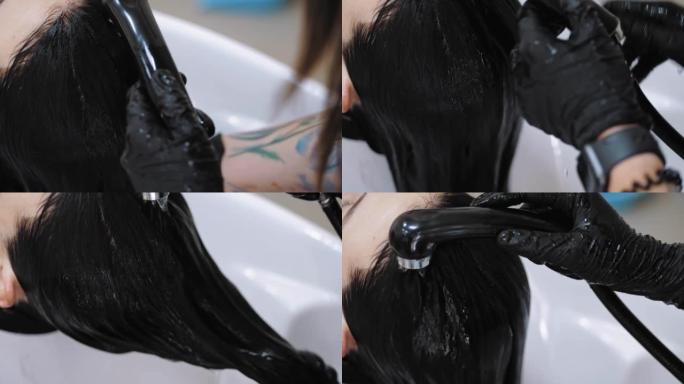 洗头。美容院的工作人员或美发师正在美容院的专业水槽用洗发水和水清洗顾客的头发。头发护理。染发。