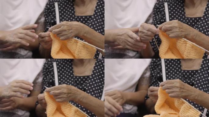 老年妇女和女儿一起编织以保护痴呆症和记忆力减退。