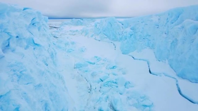 积雪覆盖的南极地表鸟瞰图飞行。