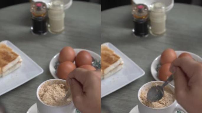 搅拌热燕麦饮料，在咖啡馆吃健康早餐。