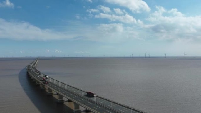 东海大桥上汽车的延时/鸟瞰图，远处是一个海上风电场。