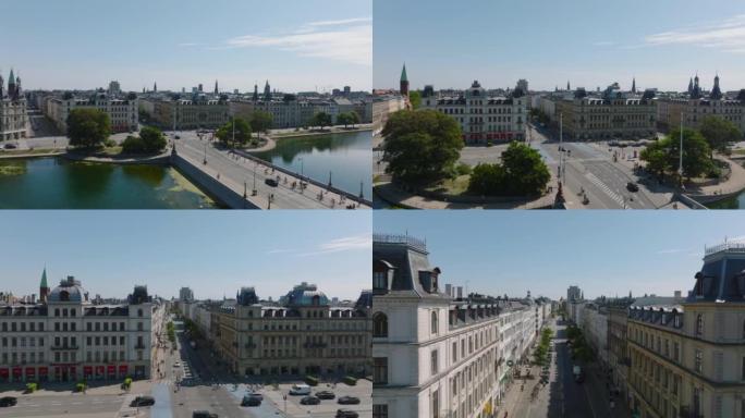 城市里阳光明媚的日子，湖上的桥梁、十字路口和街道上的交通鸟瞰图，两旁是一排排的建筑物。丹麦哥本哈根