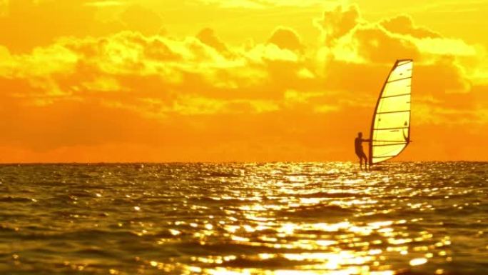日落时的帆板运动单人帆船阳光下自由