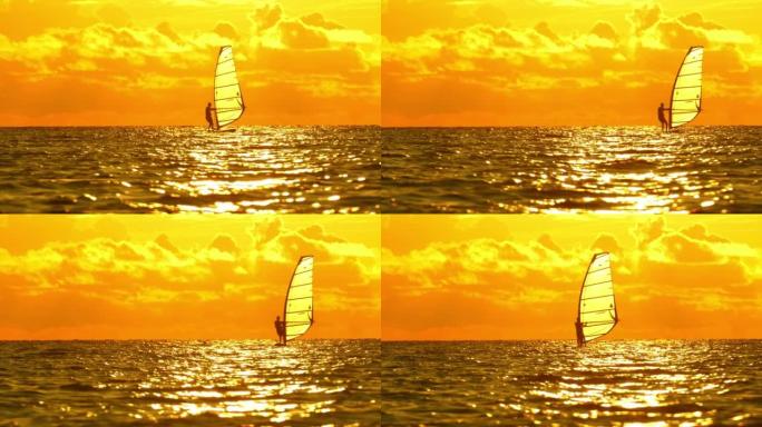 日落时的帆板运动单人帆船阳光下自由