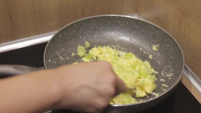 一名妇女用胡椒和奶酪准备鸡蛋-平底锅的特写镜头