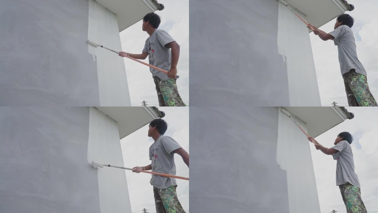画家粉刷房子的墙壁。