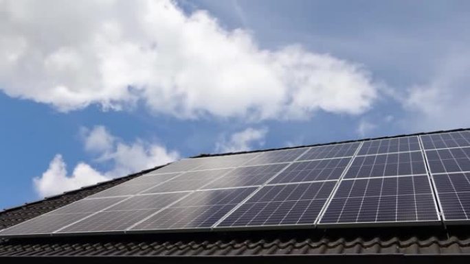 太阳能电池板上的云层和天空在住宅屋顶上产生清洁能源的时间流逝。