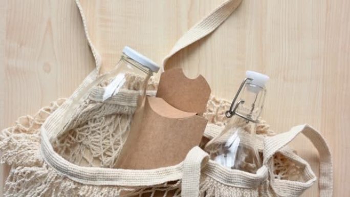 可重复使用的织物购物袋，桌子上有玻璃瓶和纸环保包装。零浪费的概念和日常生活中对塑料的拒绝。